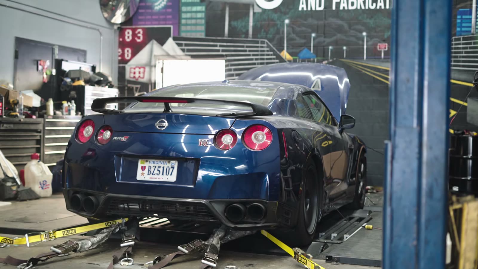 GT-R strapped to the rollers in front of the shop wall