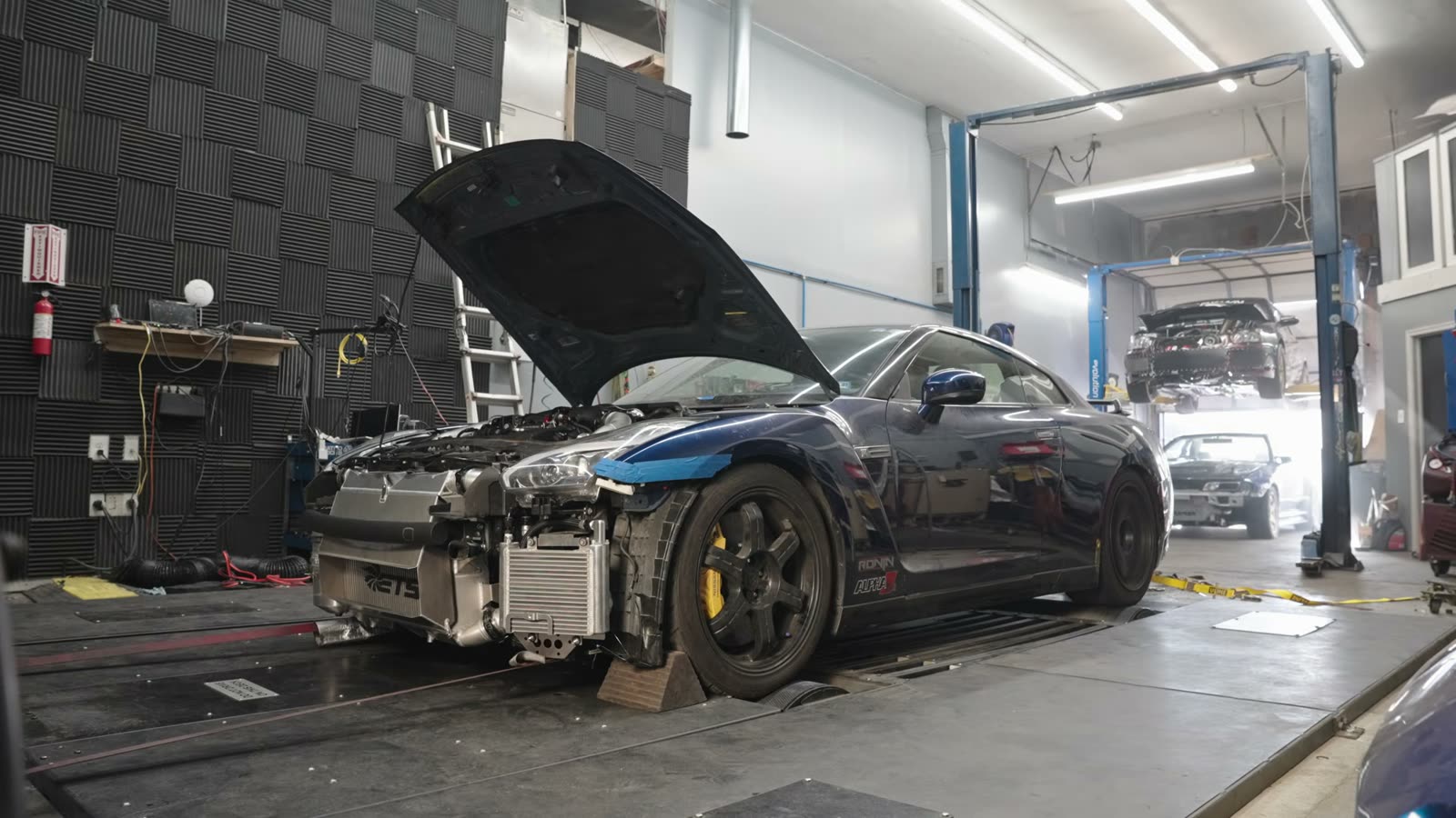 GT-R with the hood open strapped to the dyno